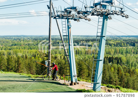 Mountain biker on the elevator at ski slope 91787898