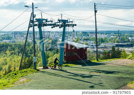 Mountain biker on the elevator at ski slope Mountain biker on the elevator at ski slope 91787903
