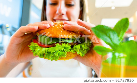 Veggie sandwich healthy vegan burger. Cute cheerful girl eating vegetarian hamburger with salad, avocado, vegetable. Hamburger vegan healthy diet food. Veggie sandwich healthy vegan burger. Cute cheerful girl eating vegetarian hamburger with salad, avocado, vegetable. Hamburger vegan healthy diet food. 91787930