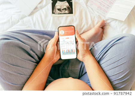 Pregnancy health app. Pregnant woman holding smartphone. Mobile pregnancy online maternity application. Concept of pregnancy, maternity, expectation for baby birth. 91787942