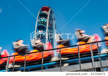 Ferris wheel and roller coaster in motion in amusement park Ferris wheel and roller coaster in motion in amusement park 91788075