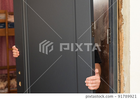 The craftsman installs the door leaf on the hinged hinge. The craftsman installs the door leaf on the hinged hinge. 91789921