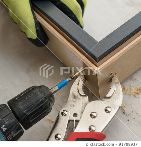 Drilling a hole in the door frame for a corner connection. 91789937