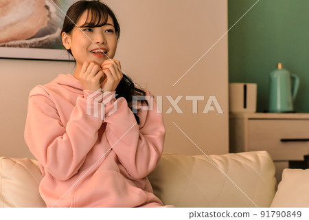 驚訝的年輕女子晚上看電視 驚訝的年輕女子晚上看電視 91790849
