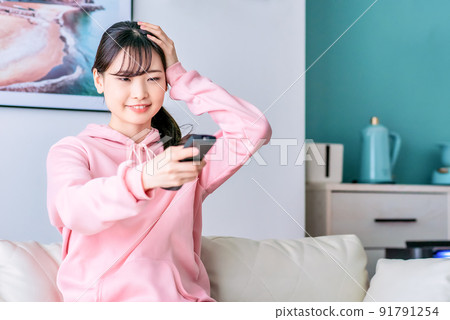 一個年輕女子驚訝地看電視 91791254