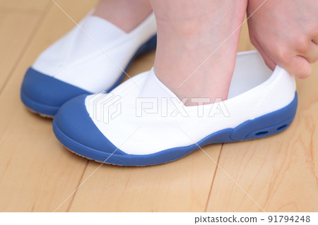 Girls' feet wearing slippers 91794248