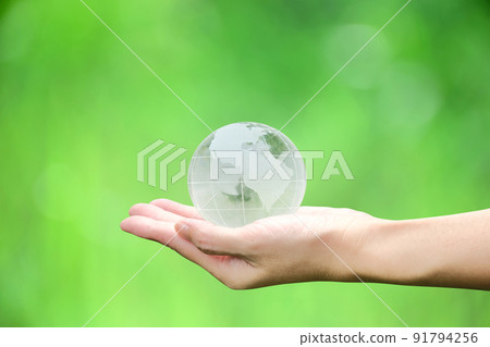 Crystal globe in hand with green background, concept for eco friendly business, green energy and climate change. Crystal globe in hand with green background, concept for eco friendly business, green energy and climate change. 91794256