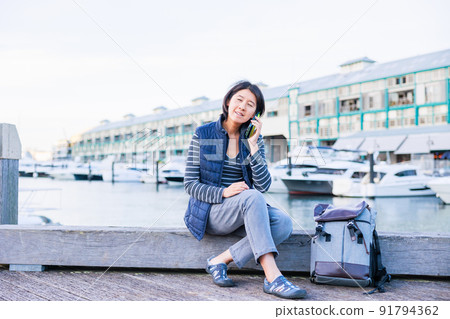 A woman talking on a mobile phone at the dock A woman talking on a mobile phone at the dock 91794362