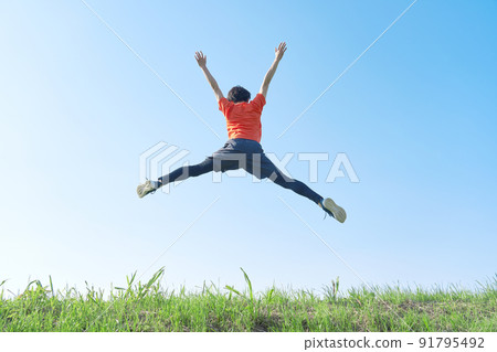 Back view of a sportsman jumping outdoors 91795492