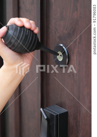一位女士正在清理入口處的鑰匙孔 91796083