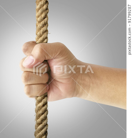 Hand holding tight onto rope. Hanging on, strength and determination, people in need of help concept 91799287
