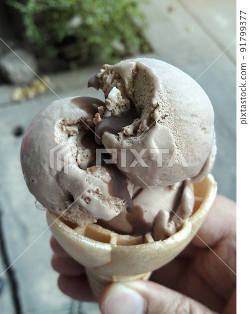 A man hand holding an ice cream cone on a white background 91799377