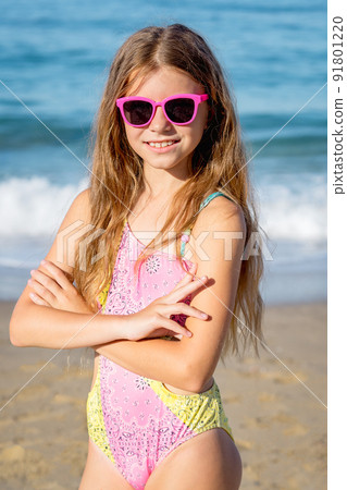 Fashion cute young girl posing on the beach in a summer swimsuit. 91801220