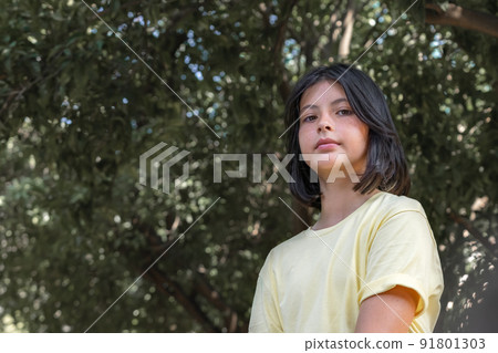 Bottom view, portrait of a teenager girl in a yellow T-shirt. Bottom view, portrait of a teenager girl in a yellow T-shirt. 91801303