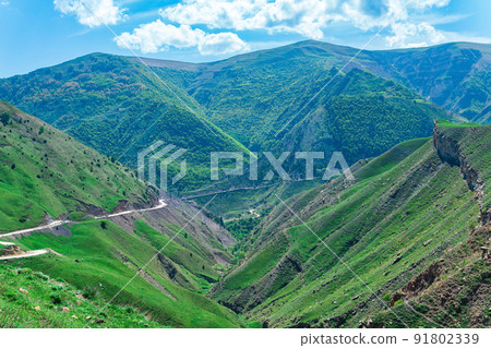 landscape of a mountain valley in the caucasus with a road crossing it 91802339