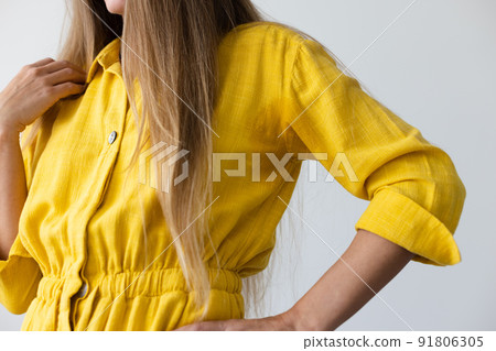 Woman in yellow dress with wet armpits. Closeup. Woman in yellow dress with wet armpits. Closeup. 91806305