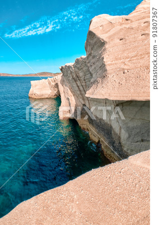 Unique rocks of Sarakiniko beach, Aegean sea, Milos island , Greece. No people, empty cliffs, summer sunshine, clear sea waters, cyan-pinkcolors 91807367
