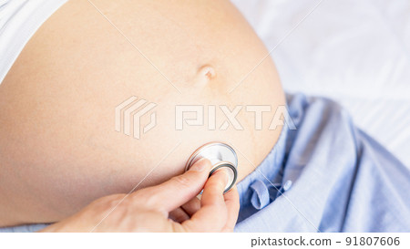 Doctor consultation pregnant woman. Medical clinic for pregnancy consultant. Doctor examining pregnancy woman belly holding stethoscope. Concept maternity, pregnancy, childbirth. 91807606