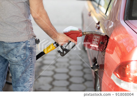 Man filling fuel tank in his hand at gas station. Sanctions economy crisis 91808004