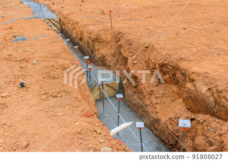 Foundation of a house under construction with building a strip reinforcement frame Foundation of a house under construction with building a strip reinforcement frame 91808027