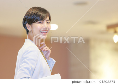Business woman looking back at the tablet _ There is movement in the left hand Business woman looking back at the tablet _ There is movement in the left hand 91808873
