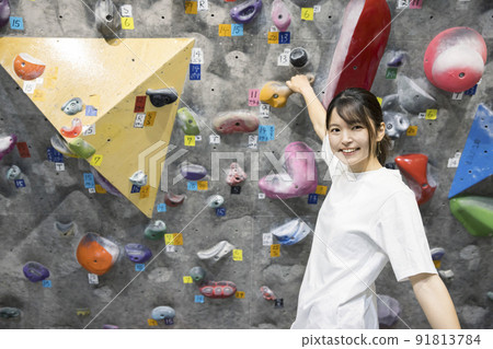 Young woman bouldering Young woman bouldering 91813784