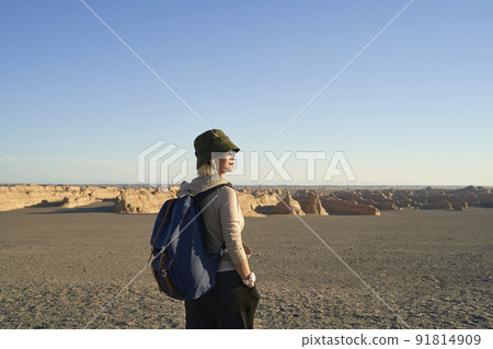 asian woman backpacker looking at view of the yardang landform in gobi desert 91814909