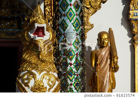 Gold Phra Sivali or Phra Sivalee Buddhist Monk Statue standing front of Thai Church in Wat Phra That Choeng Chum Worawihan It is an important sacred place of the Thailand. Gold Phra Sivali or Phra Sivalee Buddhist Monk Statue standing front of Thai Church in Wat Phra That Choeng Chum Worawihan It is an important sacred place of the Thailand. 91815574