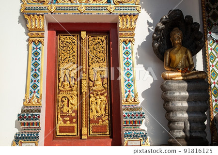 The exquisite patterns of Thai art decorate the concrete doors at Wat Phra That Choeng Chum Worawihan. It is an important sacred place of Thailand. The exquisite patterns of Thai art decorate the concrete doors at Wat Phra That Choeng Chum Worawihan. It is an important sacred place of Thailand. 91816125