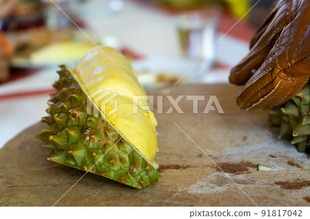 Durian Seller are showing how to open and explain informations and details to audiences about type of durain on the lunch table. 91817042