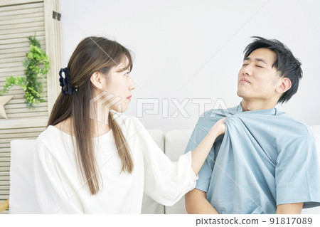 A woman who grabs a man's chest in the living room A woman who grabs a man's chest in the living room 91817089