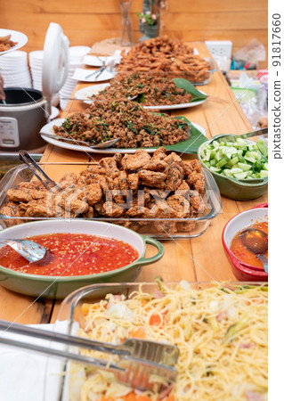 fucusing on the pile of Thai fried fish paste meat balls in glass triangle dish and the others Thai food beside and around it. All are stand by for lunch. fucusing on the pile of Thai fried fish paste meat balls in glass triangle dish and the others Thai food beside and around it. All are stand by for lunch. 91817660