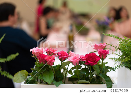 flowers decorate on the dinning long table in the luxury relax event with the blur social people behind 91817669