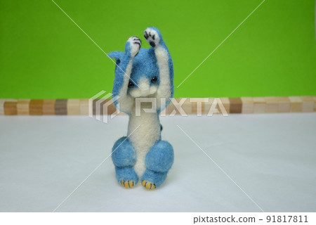 Felt doll of a cat sitting with its front legs raised 91817811