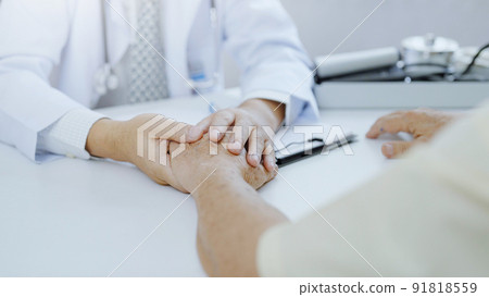 Hand of doctor comforting patient at consulting room Hand of doctor comforting patient at consulting room 91818559