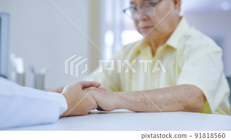 Hand of doctor comforting patient at consulting room Hand of doctor comforting patient at consulting room 91818560