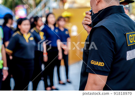 head of security guard call meeting and talk into walkie talkie for communication to the team. head of security guard call meeting and talk into walkie talkie for communication to the team. 91818970