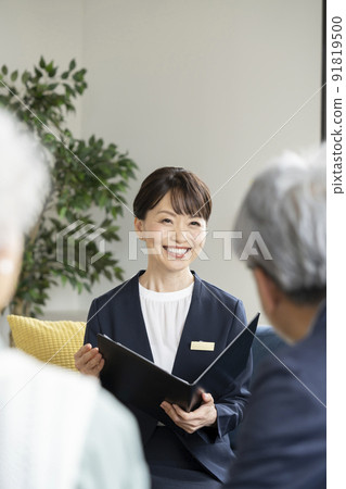 Middle-aged saleswoman talking to a senior couple 91819500