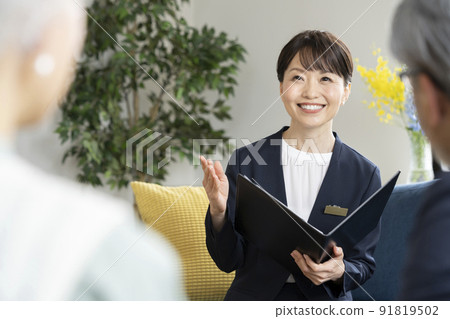 Middle business woman talking to a senior couple 91819502