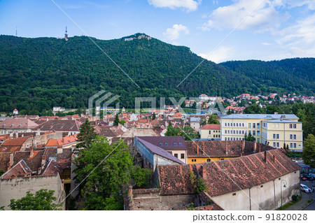 Private houses with reddish-brown tiled roofs in the old town seen from the black tower of Brasov in Transylvania, Romania 91820028