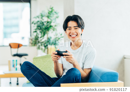 Young man playing games in the living room 91820117