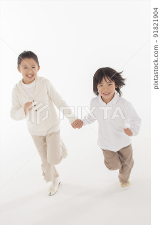 Siblings running hand in hand Siblings running hand in hand 91821904