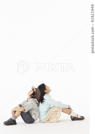 Siblings sitting and looking up 91821949