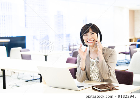 Business women office laptop smartphone calls 91822943
