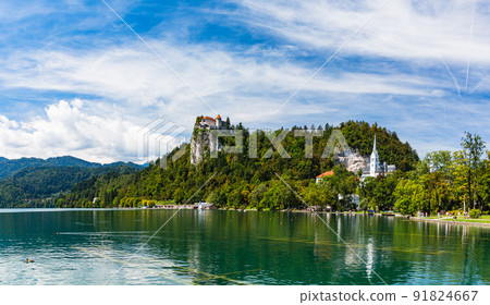Slovenia Lake Bled, St. Martinus Church on the shore and Bled Castle on a cliff Slovenia Lake Bled, St. Martinus Church on the shore and Bled Castle on a cliff 91824667