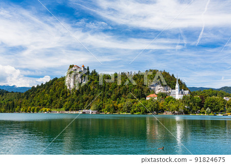 Slovenia Lake Bled, St. Martinus Church on the shore and Bled Castle on a cliff Slovenia Lake Bled, St. Martinus Church on the shore and Bled Castle on a cliff 91824675