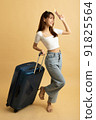 Young Asian girl dress in white shirt and jeans ready to travel on vacation on yellow isolated background 91825564