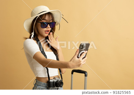 Young Asian girl dress in white shirt and jeans ready to travel on vacation on yellow isolated background Young Asian girl dress in white shirt and jeans ready to travel on vacation on yellow isolated background 91825565