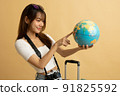 Young Asian girl dress in white shirt and jeans ready to travel on vacation on yellow isolated background 91825592
