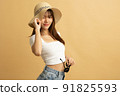 Young Asian girl dress in white shirt and jeans ready to travel on vacation on yellow isolated background 91825593